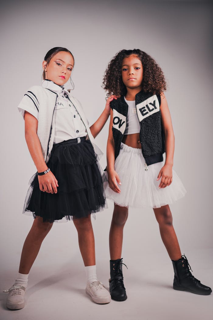 Two stylish young girls posing confidently in fashionable outfits.